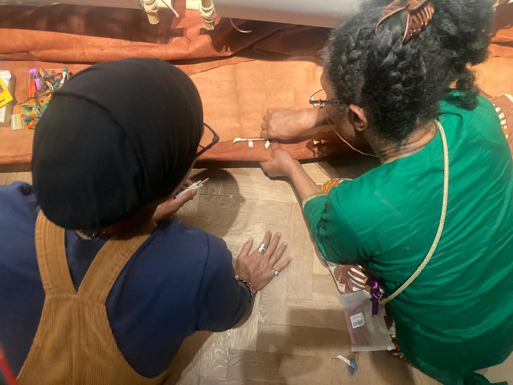 over shoulder shot of two women sewing